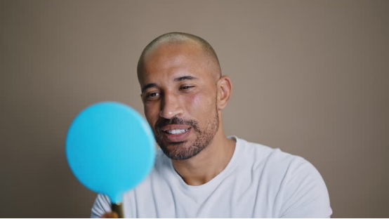 Man uses a head shaver for a precise bald shave, expressing his personal style with a smooth finish